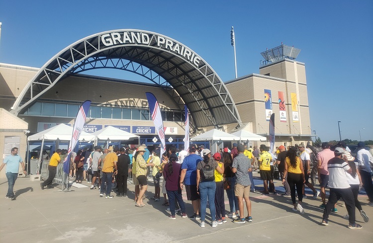 A group of people standing around in front of an airport.