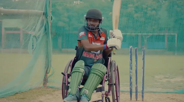 A man in a wheelchair playing cricket.