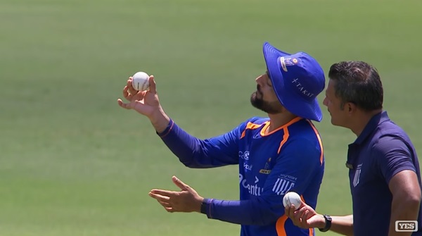 A man in blue and white holding a baseball.